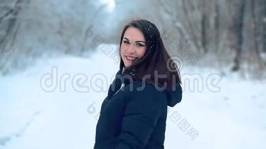 一个美丽<strong>的</strong>年轻女孩在<strong>寒冷的</strong>雪林中享受<strong>冬天的</strong>散步。
