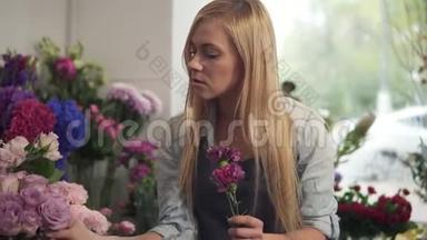 年轻的女<strong>花店</strong>老板在她的店里工作和准备花的安排，带着<strong>新鲜</strong>的花。 她是