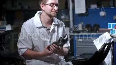 一位科学家工程师正在测试一种电子仿生假肢。 他用机械手臂的塑料手指
