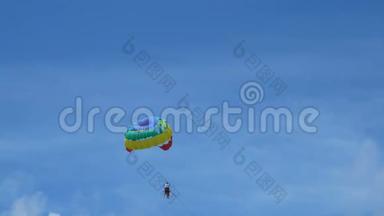 4K. 兴奋的游客挂在空中飞高，户外极限运动夏季活动。 彩色降落伞