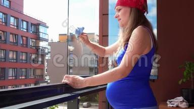 怀孕的妻子，女人，清洁玻璃，透过窗户<strong>看房</strong>子阳台