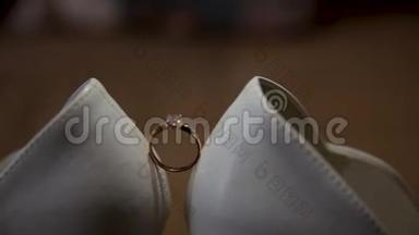 白色鞋子之间的结婚戒指。