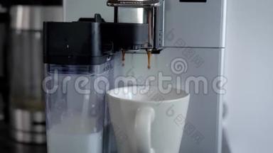 家用咖啡机早上在厨房里生产卡布奇诺，在杯子里倒入<strong>热饮料</strong>