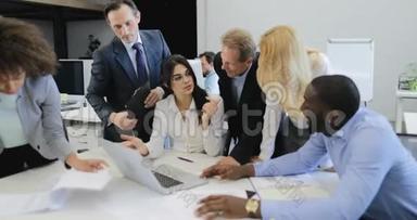 一群商界人士在办公室开会时为取得好成绩而欢呼雀跃，成功的团队讨论