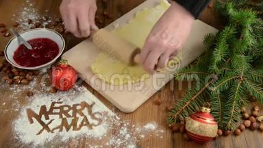 圣诞烘焙工艺，红球，圣诞装饰，糕点.. 面粉圣诞快乐在桌子上。 饼干