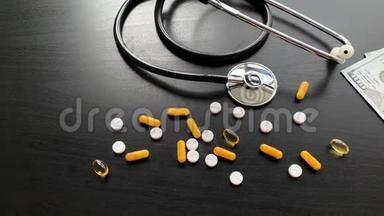 医疗账单。 黑色桌子上的彩色药丸和胶囊。 药房主题，胶囊药丸与药物抗生素