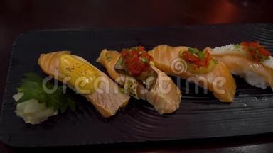 日式寿司的各种品种在日本餐馆的餐盘上分开。