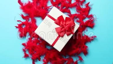 带有礼物的盒子，系在红色羽毛上的丝带上