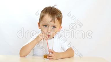 快乐的孩子通过吸管喝果汁，坐在桌子旁微笑。 <strong>运动摄像机</strong>滑块