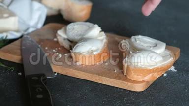 妇女用手腌制的三明治，面包、黄油和鸡蛋放在<strong>黑色背景</strong>的<strong>木板</strong>上。做三明治。