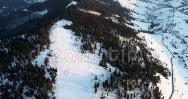 空气视图。 飞越冰冷的松林，向冬季度假胜地和滑雪坡飞去。 滑雪跑道冬季太阳升起