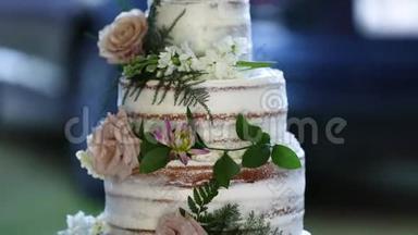 婚礼蛋糕白色花朵，背景有绿色植物