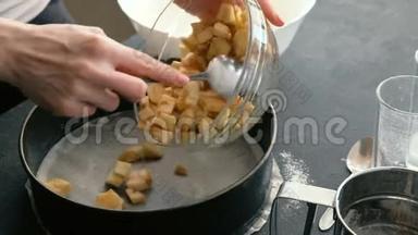 特写的女人`她的手把苹果摊在一张铺着羊皮纸的烤盘上。 做苹果派。