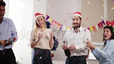 一群年轻人在办公室里庆祝圣诞节和新年，开着一瓶起泡葡萄酒和啤酒