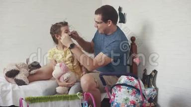 这位年轻的父亲花时间和他的小女儿在一起。 爸爸给女儿编辫子，和她和傻瓜玩