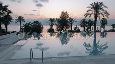 日落景色的度假胜地，游泳池俯瞰大海和棕榈，土耳其