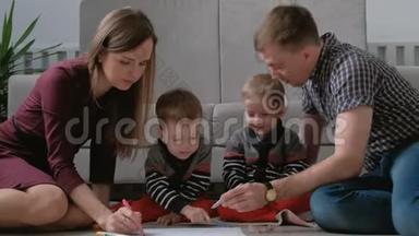 一家人的妈妈、爸爸和两个双胞胎兄弟一起画记号，摸着笔坐在地板上。