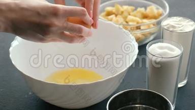 特写女人`手把鸡蛋打碎成白色的碗。