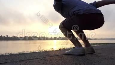 Ypoungman在夏季日落的河岸上高举