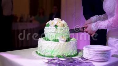 新娘切婚礼蛋糕。 新娘和新郎正在切婚礼蛋糕。 新郎新娘的手切一片