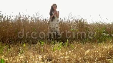 美丽的黑发女孩考虑小麦种子。 这个小女孩在俄罗斯成熟的领域付出了代价