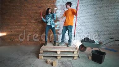 建筑工人和带工具的女孩。 在房子里修理。 尽情跳舞吧。