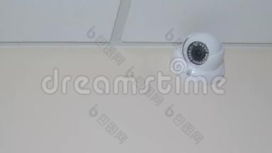 闭路电视位于天花板下的墙上，白色圆形<strong>监控摄像</strong>机