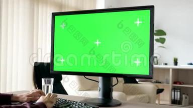 无法辨认的人在个人电脑键盘上打字，带有绿色<strong>大屏幕</strong>色度模型