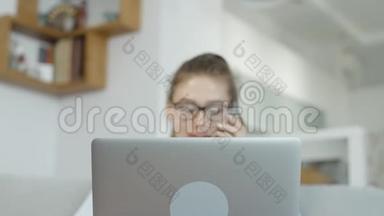 快乐女孩在家里用手提电脑，在社交网络上聊天，微笑