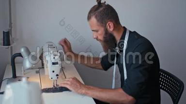 帅气的大胡子裁缝正在为他的时尚创业做缝纫机