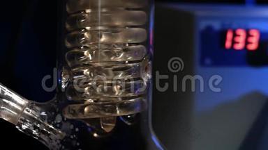 水晶螺旋。 螺旋玻璃管与水关闭。 玻璃螺旋管从回流冷凝器与自来水