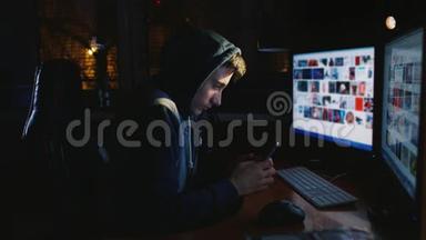 那个十六岁的家伙深夜坐在电脑附近，用手机。 青少年网瘾