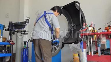 亚洲技术人员<strong>正在修理</strong>车库里的轮胎.