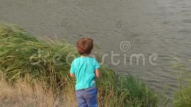 小男孩向湖里扔石头，慢悠悠。