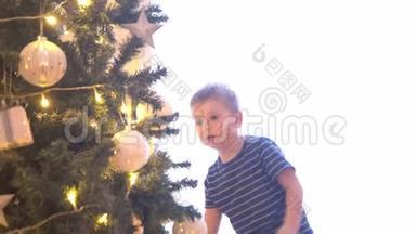 可爱的小男孩用球和灯装饰圣诞树。在家里准备<strong>过年</strong>的孩子。