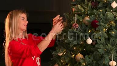 女人用圣诞彩灯装饰圣诞树的手。