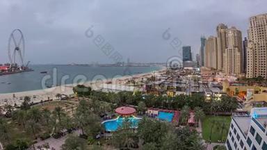 鸟瞰海滩和游客步行在JBR与摩天大楼日夜在迪拜，阿联酋