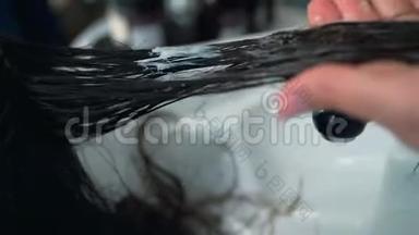 在沙龙里的白种人女人用专业的化妆师做头发处理。 专业洗头，按摩面膜