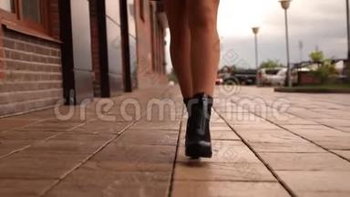 一位年轻女子在城市里散步时腿的特写