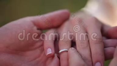 婚礼戒指宏观特写把戒指戴在手指上的白金钻石珠宝