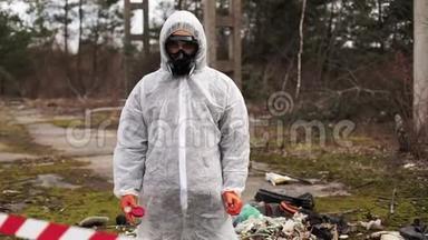 穿着生物危险服和防毒面具的人站在满是废物的地方的条纹后面