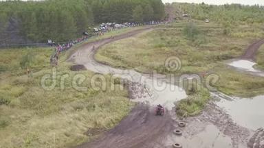 四轮自行车赛道的景观。 剪辑。 四轮自行车在比赛中通过泥坑的俯视图。 越野摩托车
