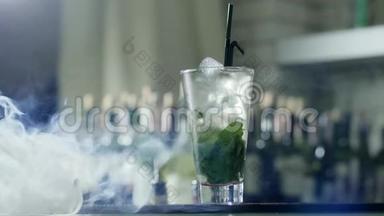 冰镇饮料，用冰块和绿色薄荷叶<strong>放入</strong>大玻璃杯中，用黑色塑料吸管站在烟柜上