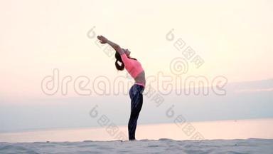 健康的年轻美女在沙滩上、海边、河边、黎明时分、黎明时分，练习瑜伽