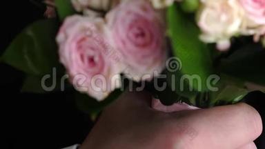 一个穿西装的男人手里拿着一束五颜六色的玫瑰。 特写镜头。 送给心爱的人美丽的鲜花礼物