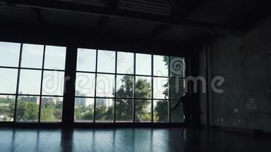 一位<strong>芭蕾</strong>舞演员的<strong>剪影</strong>，以一扇大窗户为背景。 <strong>舞蹈</strong>演员跳得很高。 慢动作