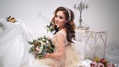 美丽的新娘被<strong>婚纱</strong>包围，围绕着花束和装饰。 直接看着<strong>摄</strong>像机，大