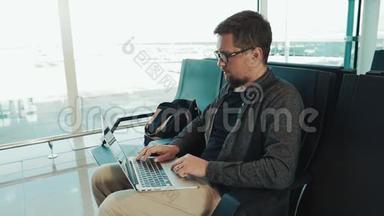 在机场带笔记本电脑的男游客。