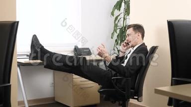 年轻人坐在办公室，用手机说话，挤压手<strong>扩张</strong>器。 60英尺