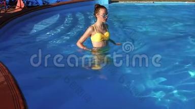 一个<strong>身材好</strong>的成年女孩进入室外游泳池的水中